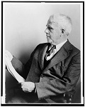 Robert Frost, half-length portrait, seated, facing left