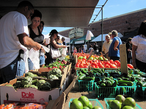 Consumers shop for local produce at the Winter Park farmers market in Winter Park, FL.