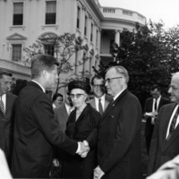 Kellogg shaking hands with President John F. Kennedy