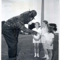Smokey Bear greets three youthful fans in Washington, D.C. 