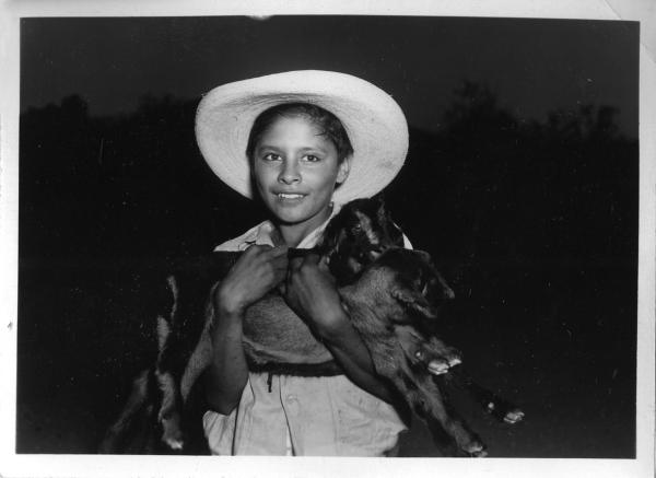 Mexican boy holding baby goats