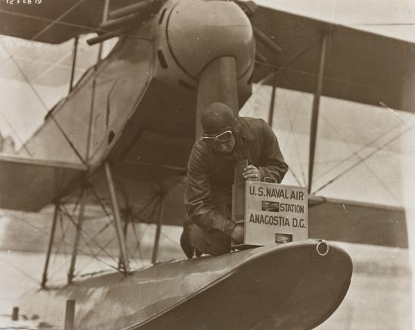 Man releasing a messenger pigeon on an airplane